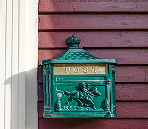 Green with Gold Old Fashioned Post Box on Wall Depicting a Rider and Horse.